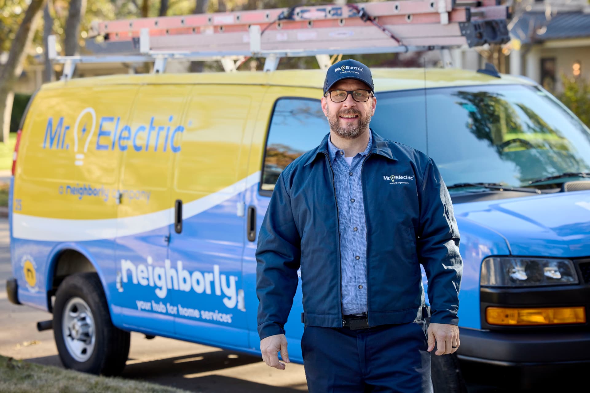 Mr. Electric service professional standing beside a branded Mr. Electric van